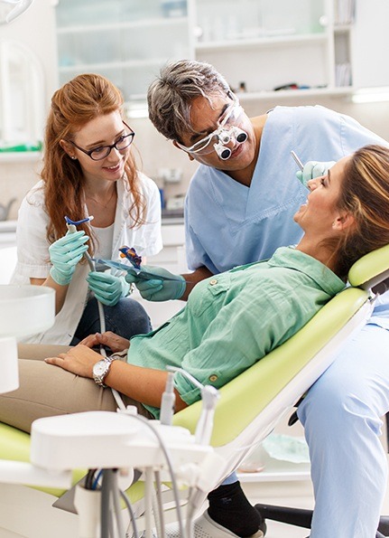 Dentist and team member treating relaxed dental patient